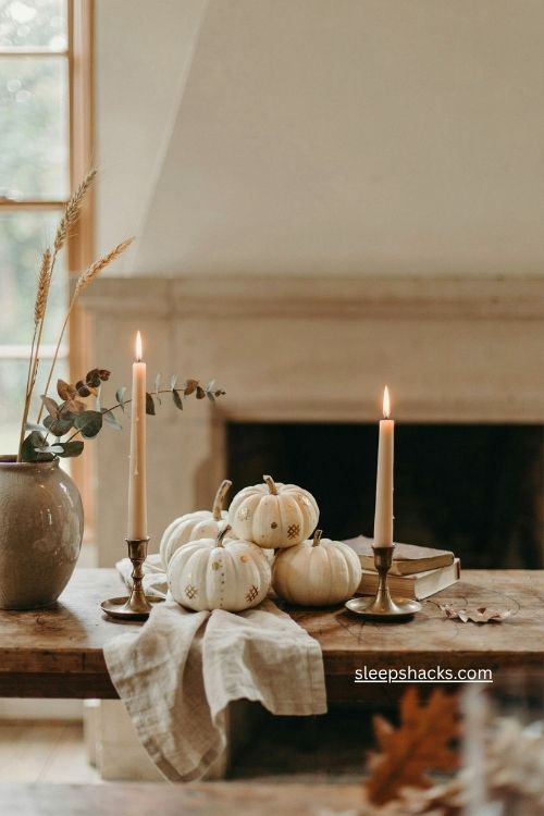 White pumpkins with delicate gold details on a neutral fall mantel 