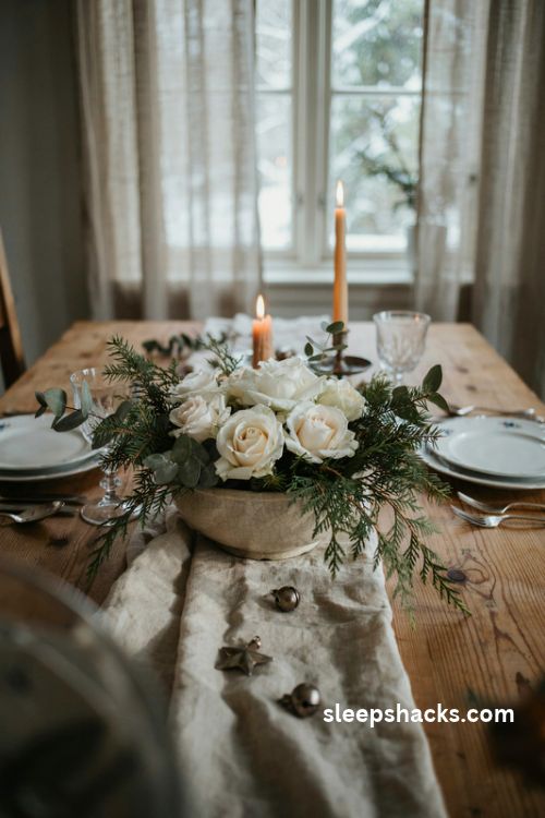 White roses with fresh pine and eucalyptus in a low Christmas table centerpiece