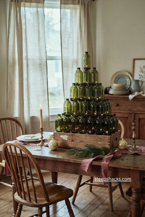 Wine bottle christmas tree with glowing green glass bottles and cozy vintage holiday decor 
