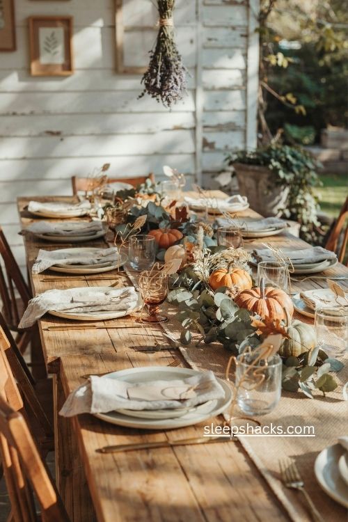 Wire leaf thanksgiving place card holders with gold stems and linen napkins 