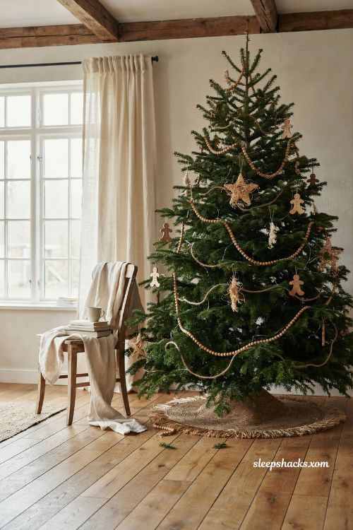 Wood bead garland and natural straw star ornaments on a rustic gingerbread christmas tree