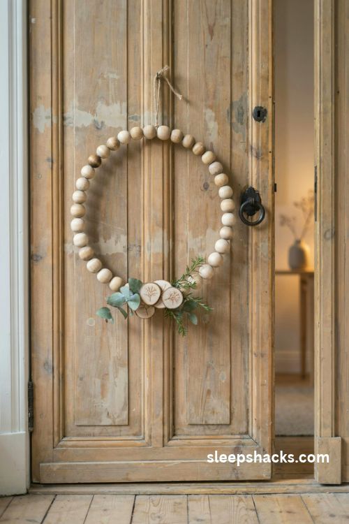 Wood slice and natural wooden bead christmas wreath with jute hanger and dried greenery on a farmhouse door