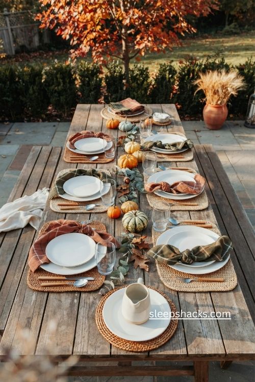 Woven placemats with white plates and plaid napkins thanksgiving table