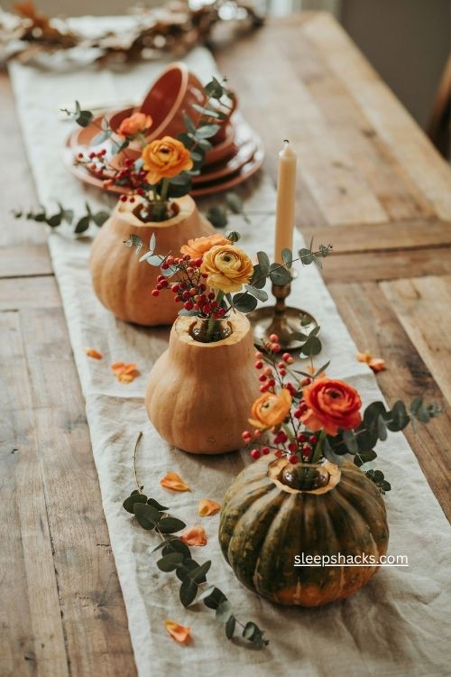 fall gourd bud vases with orange ranunculus pepperberry and seeded eucalyptus 