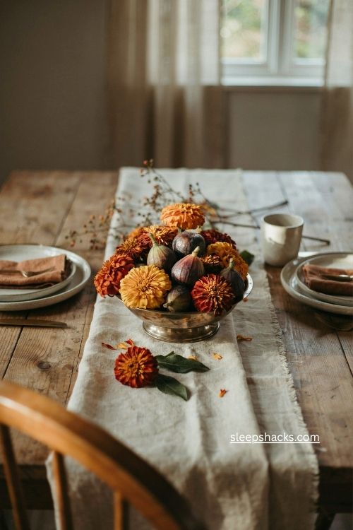 fall marigold centerpiece with orange flowers and dark purple figs in low bowl 