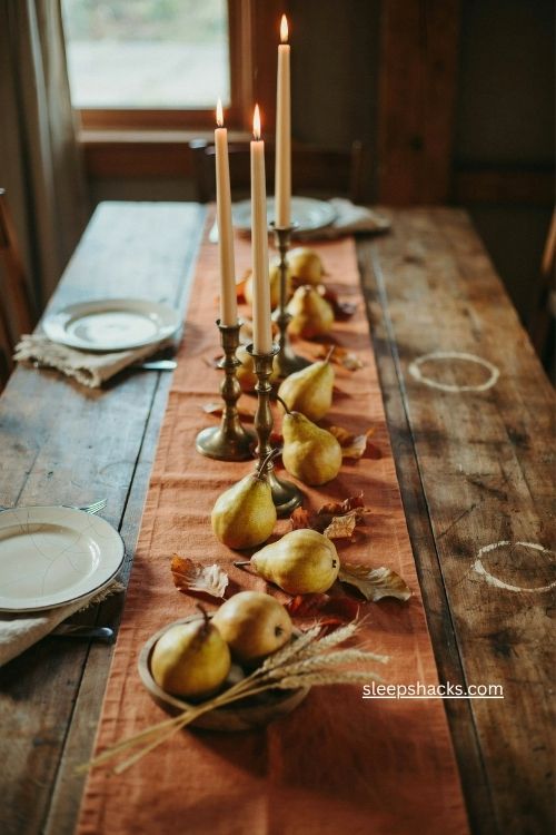 pear and taper candle fall centerpiece with brass candlesticks and autumn leaves 