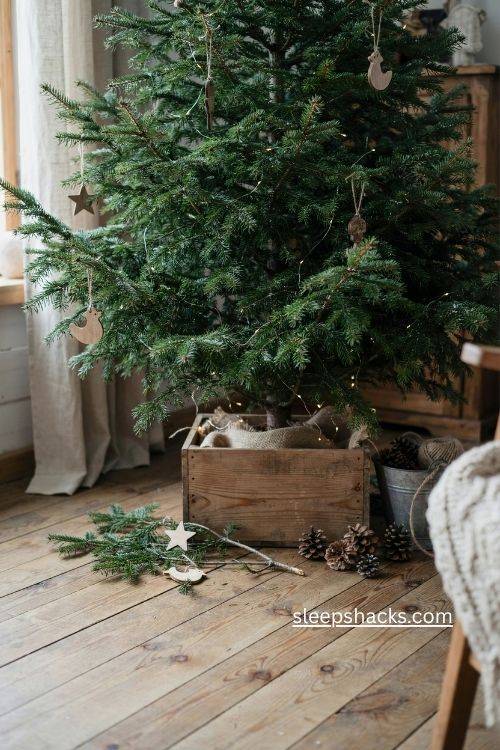 woodsy christmas tree in rustic wooden crate with burlap pinecones and cabin charm 