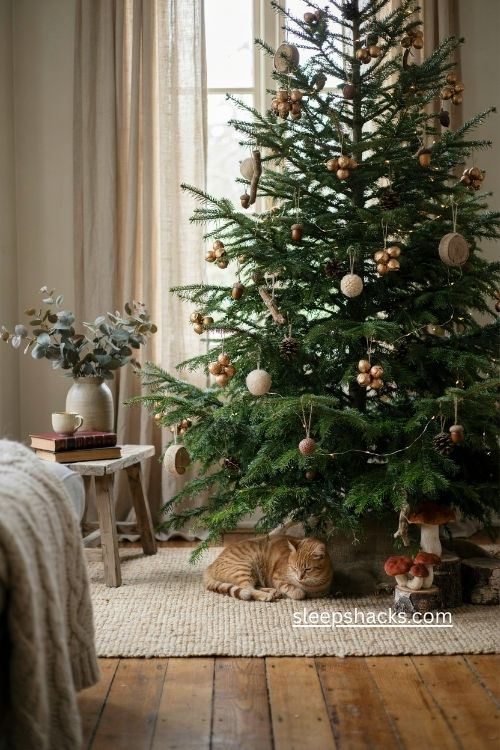 woodsy christmas tree with burnished gold seed pods pinecones and rustic ornaments 